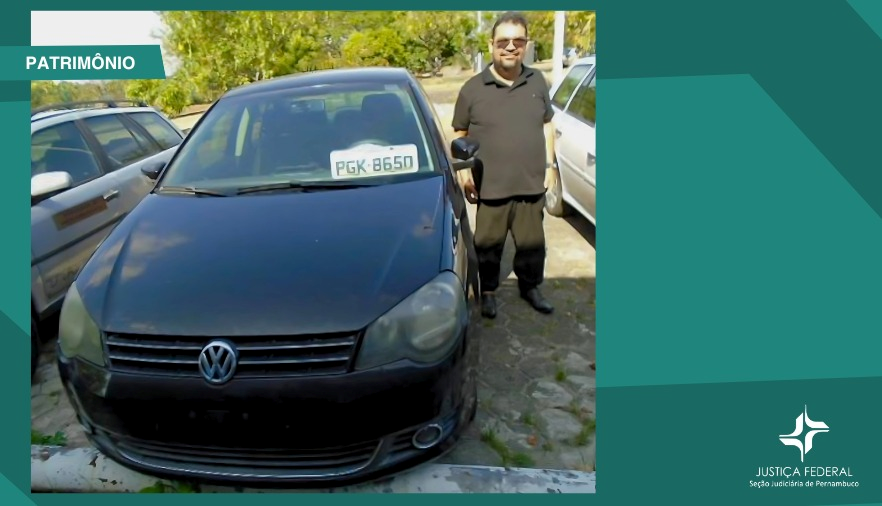 Foto com fundo verde, mostra um carro preto com um homem ao lado