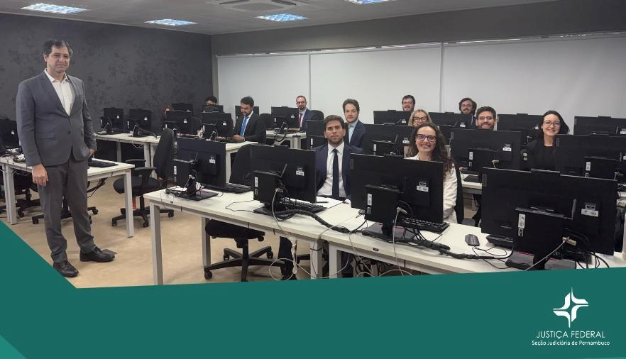 Mostra homem em pé e pessoas sentadas na frente de computadores