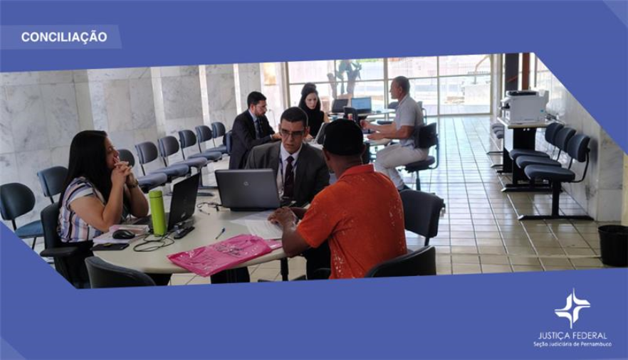 pessoas ao redor da mesa em audiência de conciliação 