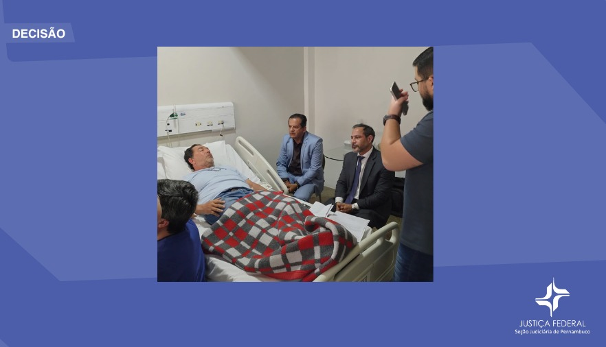 Foto registra audiência realizada com réu acamado, magistrados e servidores ao lado da cama